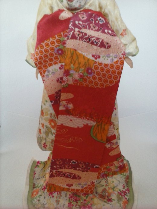 O obi da maiko são estes tecidos vermelho estampado e a "faixa" que ela possui na cintura; Foto: Magda Amaral/BC